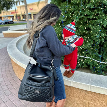 Young trendy mom with her classic black diaper bag with shoulder strap 